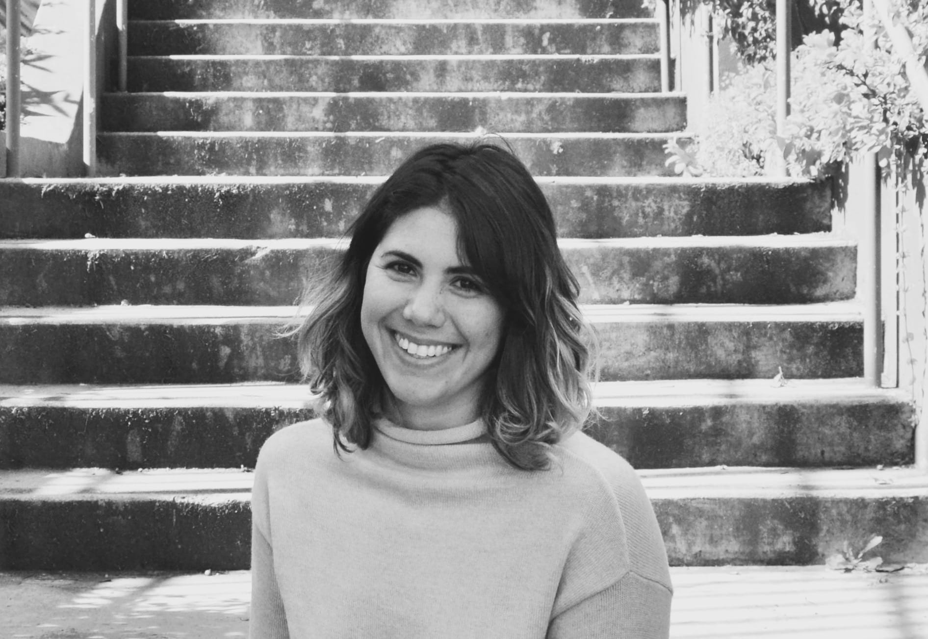 Black and white photo of Brie Wolfson in front of stairs